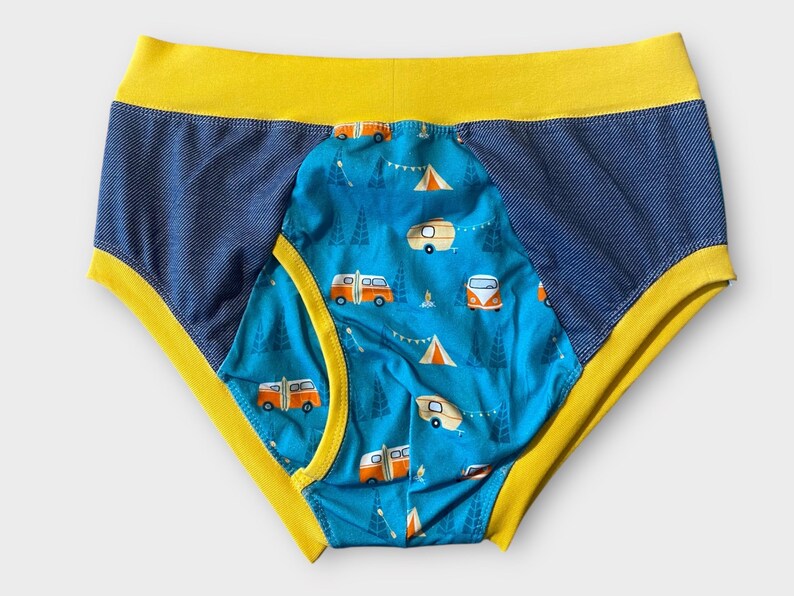 May include: Blue and yellow underwear with a pattern of orange camper vans and trees on a blue background.