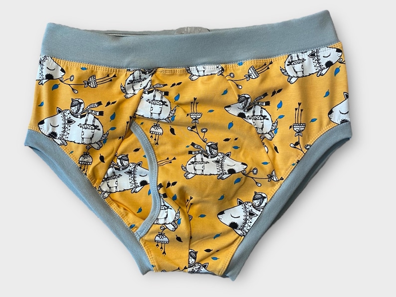 May include: Yellow underwear with a blue waistband and a repeating pattern of black and white illustrations of a dog wearing a hat and scarf.