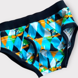 Può includere: Intimo con motivo nero e blu con un design geometrico e figure colorate.