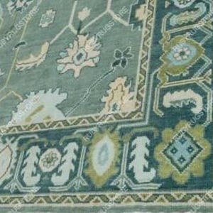 May include: A teal blue rug with a floral pattern in shades of cream, light blue, and green. The rug has a border with a geometric design.