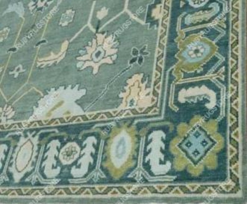 May include: A teal blue rug with a floral pattern in shades of cream, light blue, and green. The rug has a border with a geometric design.