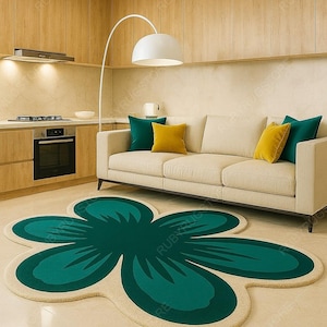 May include: A flower-shaped rug in a living room setting. The rug features a teal green center with a beige border. A beige sofa with teal and yellow throw pillows sits against a light wood paneled wall. A white floor lamp and kitchen appliances are also visible.