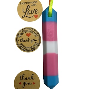 May include: A colorful, geometric pendant with a blue, pink, and white gradient design. The pendant is attached to a multicolored cord. The image also includes three round stickers with text that reads "handmade with Love", "thank you", and "thank you for supporting our small business".