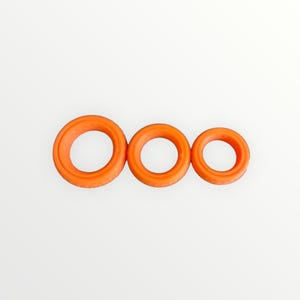 Può includere: Tre guarnizioni toriche arancioni di diverse dimensioni sono disposte orizzontalmente su uno sfondo bianco. Le guarnizioni toriche sono circolari con un foro centrale. L'anello più grande è a sinistra, seguito da un anello medio e piccolo. Misure in cm.