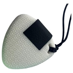 Könnte beinhalten: Weißer Onigiri-Anhänger aus Silikon mit einem schwarzen Nori-Detail aus Silikon. Der Anhänger ist an einer schwarzen Schnur befestigt.