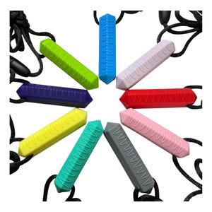 Könnte beinhalten: Ein Set aus zehn bunten Silikon-Kauketten mit verschiedenen Texturen. Jede Kette hat eine andere Farbe und ein anderes Muster, und sie sind alle auf schwarzen Schnüren aufgefädelt.