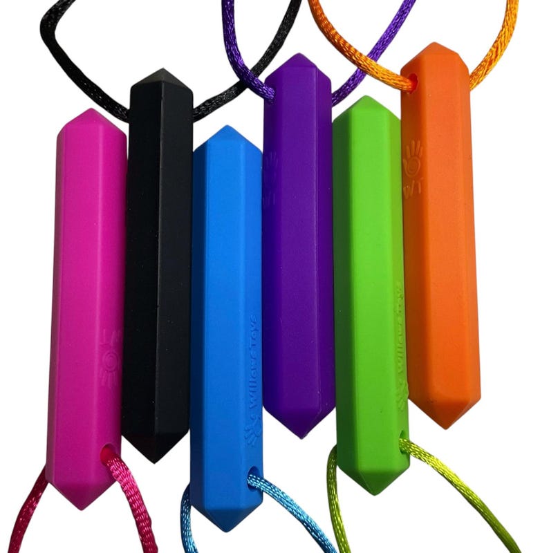 May include: A collection of six colorful, geometric-shaped chewable necklaces. The necklaces are in shades of pink, black, blue, purple, green, and orange. Each pendant is suspended from a matching or complementary colored cord. The brand name "Willow Toys" is printed on some of the pendants.