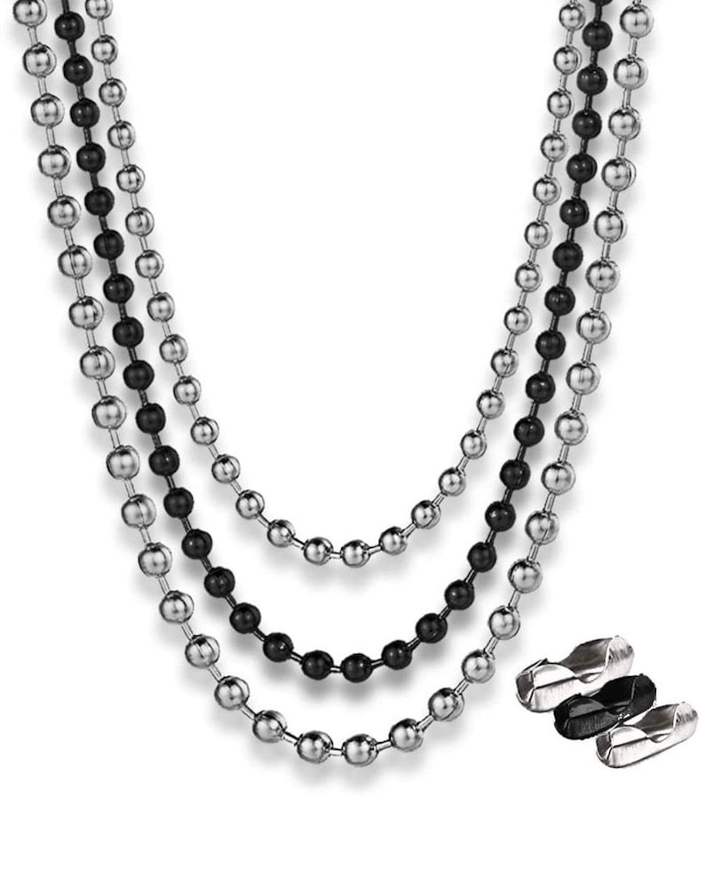 May include: Three layered necklace featuring silver and black ball chains. The chains are made of small, round beads and are displayed against a white background. The necklace has a modern and minimalist design, suitable for everyday wear.
