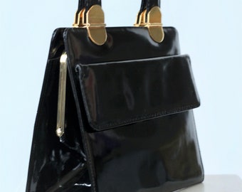 Bon Goût 1980s black patent leather top handle bag with golden closure and buckle.