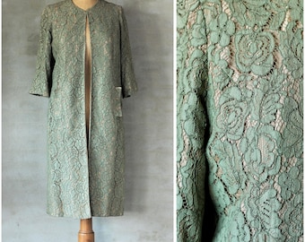 Può includere: Un lungo cappotto di pizzo verde con un motivo floreale. Il cappotto ha un colletto alla coreana e maniche lunghe. È aperto sul davanti e ha una tasca sul lato sinistro.