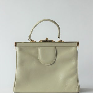 Bolso Bon Goût de los años 60, de piel blanca con asa superior y detalles en lino y piel roja // Estructura metálica dorada // Fabricado en Dinamarca, Copenhague // Proveedor de la Corte Real