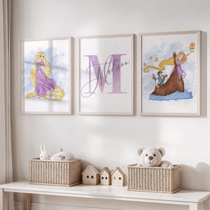 Puede incluir: Tres impresiones enmarcadas en acuarela con temática de princesas. Una impresión muestra a una princesa con pelo largo y rubio con un vestido morado. Otra tiene el nombre "Madison" en fuente morada. La tercera muestra una princesa en un barco con linternas.