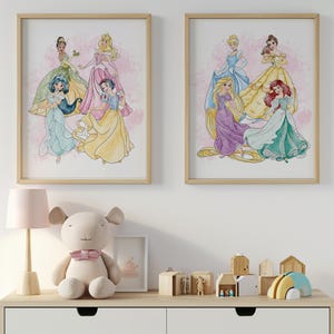 Puede incluir: Dos impresiones enmarcadas en acuarela con princesas de Disney con vestidos coloridos. La obra de arte está sobre un fondo rosa de acuarela. Los marcos son de color madera clara. Las impresiones se exhiben encima de una cómoda blanca.