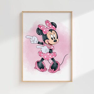 Puede incluir: Una impresi&oacute;n enmarcada con Minnie Mouse con un vestido y lazo de lunares rosas. El personaje de dibujos animados est&aacute; se&ntilde;alando con ambas manos sobre un fondo rosa de acuarela. La obra de arte est&aacute; en un marco de madera.