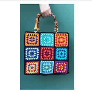 May include: A colorful crocheted handbag with a bamboo handle. The bag is made of squares of different colors, including red, orange, yellow, green, blue, and purple.