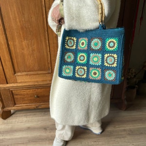 Crocheted bag of granny squares with bamboo handle. Handbag in beautiful colors. Stylish fashion accessory. Also nice as a gift.