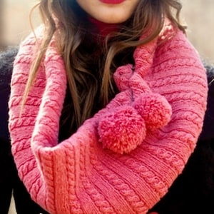 Può includere: Una sciarpa a cerchio lavorata a maglia rosa acceso con un motivo a trecce e due pompon abbinati. Questo accessorio caldo è perfetto per l'inverno. Il colore è un rosa brillante e allegro.