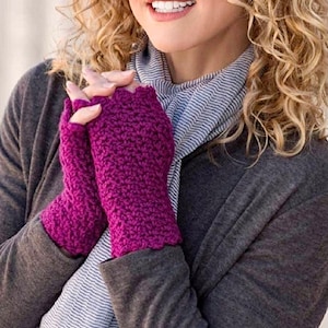 May include: A woman wearing a gray cardigan with a striped scarf and a pair of pink fingerless gloves.
