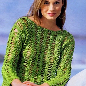 Könnte beinhalten: Ein limettengrünes Häkeltop mit langen Ärmeln und einem einzigartigen offenen Webmuster. Das Top besteht aus leichtem Material und hat eine lockere Passform. Das Model trägt das Top mit einer weißen Hose.