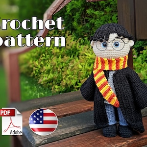 Puede incluir: Patrón de crochet para una muñeca amigurumi de Harry Potter. La muñeca lleva una túnica negra, una bufanda roja y amarilla y gafas redondas. La muñeca está sentada en un banco de madera.