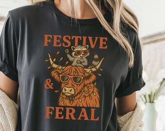 Festive and Feral Christmas Shirt – Funny Highland Cow and Raccoon Holiday Tee – Comfort Colors Unisex Top