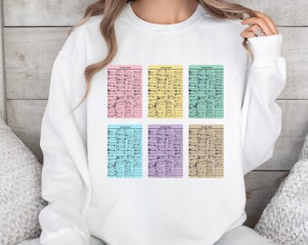 May include: White sweatshirt with six library card designs in pastel colours. Each card has the words "DATE DUE" at the top. The cards are in pink, yellow, green, blue, purple, and tan.