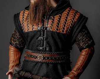 May include: A black hooded tunic featuring brown leather woven panels on the chest and shoulders, secured with three front buckles. The garment includes long brown quilted leather sleeves and a matching brown leather belt with a circular metal buckle.