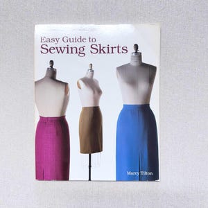 May include: A rustic wooden sign with the text "Welcome" in a handwritten style. The sign is painted white with a distressed finish, and a small, decorative heart is attached. The background is a blurred image of a wooden surface.