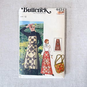 May include: A vintage Butterick sewing pattern, size 12, featuring illustrations of a woman wearing an apron and a long skirt. The apron has a star and square pattern. The pattern also includes a matching bag.