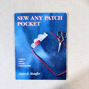 May include: A white ceramic mug with a black handle and the text "But First, Coffee" in a bold, black font. The mug is displayed on a white surface. The mug is approximately 4 inches tall.