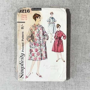 May include: A vintage Simplicity 3216 sewing pattern envelope for a Slenderette garment. The front features illustrations of three coat styles, including a floral quilted design, a light blue dress, and a solid red coat, with text indicating size 40.