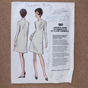 May include: Vintage Vogue sewing pattern for A-line garments. The illustration shows a woman in a short-sleeved dress. The pattern includes instructions for a perfect fit and is designed for sizes 8-20. The text on the pattern reads "Vogue's Guide to Perfect Fit of A-Line Garments."