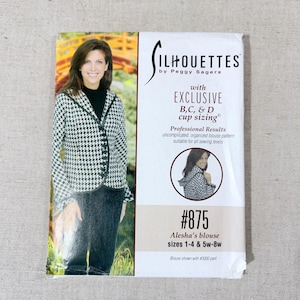 May include: A sewing pattern package for Alesha's blouse, sizes 1-4 and 5w-8w. The package features a woman wearing the blouse in a black and white houndstooth pattern. The package includes the text "SILHOUETTES by Peggy Sagers".