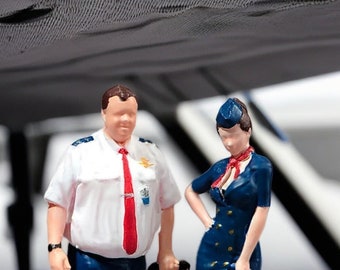 Modeler art/model scene with miniature civil aircraft captain and female flight attendant as doll figures