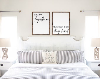 May include: A white bedroom with a white bed with a striped comforter and pillows. There are two wooden signs on the wall above the bed that say "and so together" and "they built a life they loved". There is a pillow on the bed that says "Let's Cuddle".