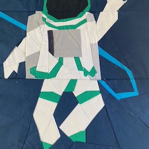 Puede incluir: Un astronauta blanco con detalles verdes flota en el espacio sobre un fondo azul oscuro. El astronauta lleva un traje espacial blanco con un casco verde y sostiene una cuerda azul.