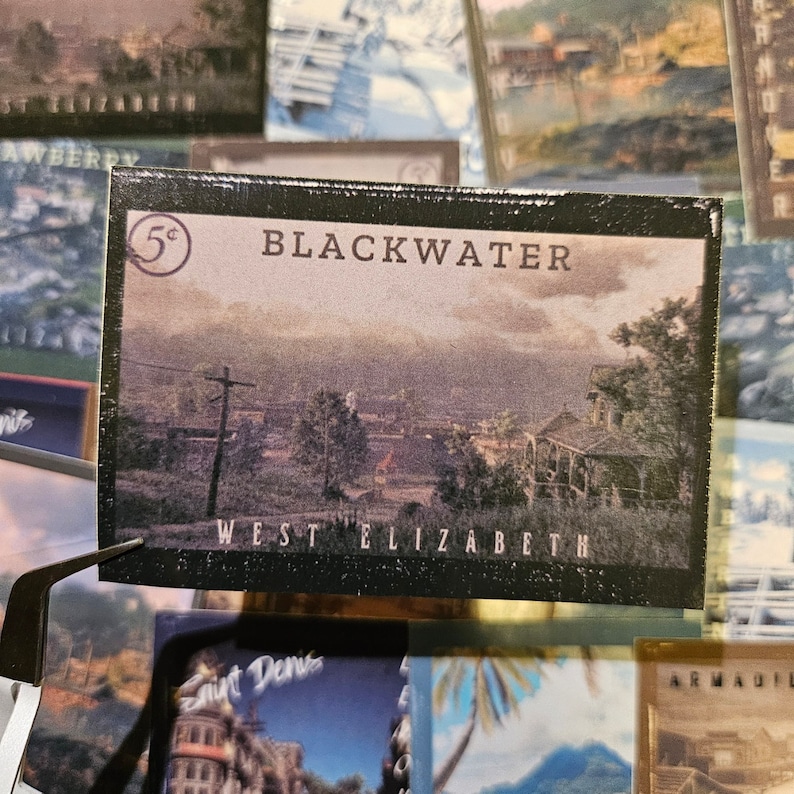May include: A vintage postcard with a black border featuring a scenic view of Blackwater, West Elizabeth. The postcard has a 5&cent; stamp in the top left corner and the text "BLACKWATER" and "WEST ELIZABETH" printed on it.