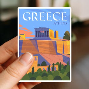 May include: A sticker featuring a stylized illustration of the Parthenon in Athens, Greece. The sticker has the word "GREECE" in white capital letters above "ATHENS" on a blue background. The image includes orange, yellow, and green elements.