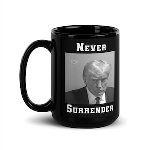May include: Black coffee mug with a white image of a man with the text "NEVER SURRENDER" printed on it.