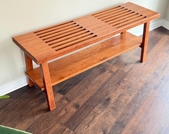 Banco de entrada: De madera de cerezo con listones y estante de almacenamiento sobre patas de madera.