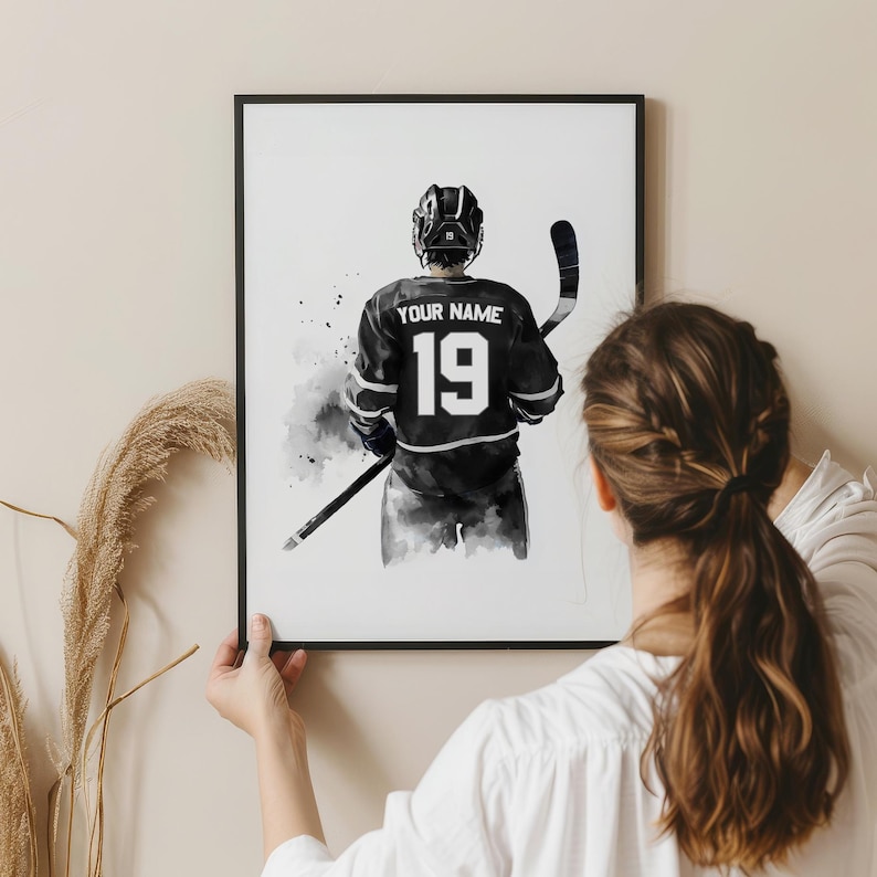 a woman holding up a picture of a hockey player