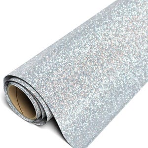 May include: A roll of silver glitter material featuring a dense, sparkling texture across the entire surface. The material is wound around a cylindrical cardboard core, showing a light-colored interior and a reflective, shimmering finish.