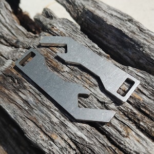May include: Two silver metal bottle openers with a unique design. The openers are made of a durable metal and have a smooth finish.