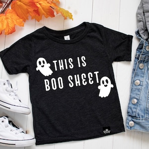 May include: Black t-shirt with white ghost illustrations and the text "This is Boo Sheet".
