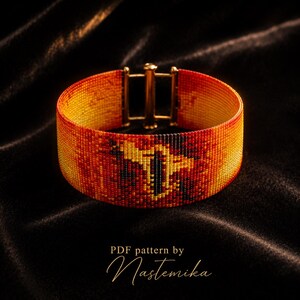 May include: A wide beaded cuff bracelet featuring a gradient of red, orange, and yellow colors with a central black and yellow geometric motif. The bracelet is secured with a gold-toned metal slide clasp. Text below reads: PDF pattern by Nastemika.