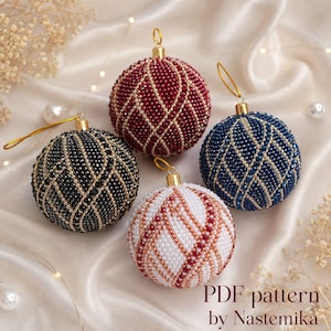 Puede incluir: Cuatro adornos navideños esféricos cubiertos con intrincados abalorios en un patrón entrecruzado. El conjunto incluye uno rojo oscuro, uno negro, uno azul oscuro y uno blanco con detalles dorados. Cada uno tiene una tapa y un lazo dorado.