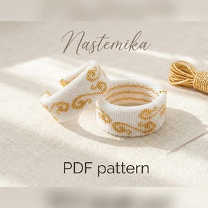 May include: Two white beaded bracelets with gold floral designs and gold accents. The bracelets are displayed on a neutral surface. The word "Nastemika" is written in cursive. The text "PDF pattern" is also visible.