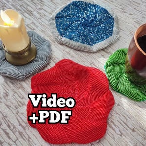 May include: Four crocheted coasters in different colors and patterns. The coasters are made of beads and are circular in shape. The coasters are on a light wood surface. The text "Video + PDF" is superimposed on the image.