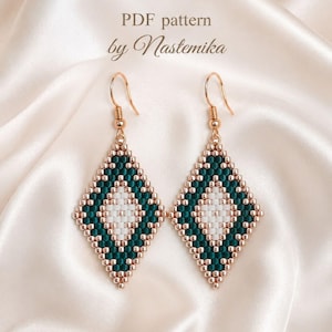 May include: A pair of diamond-shaped beaded earrings featuring a geometric pattern in dark green, white, and metallic rose gold beads. The earrings hang from rose gold-toned metal hooks. The text PDF pattern by Nastemika is visible.