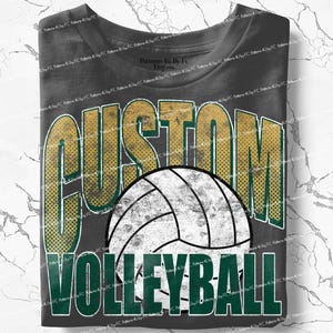 May include: Dark gray t-shirt featuring a volleyball design. The shirt has the word "CUSTOM" in gold and green, with a white and black volleyball graphic. Below the volleyball is the word "VOLLEYBALL" in green.